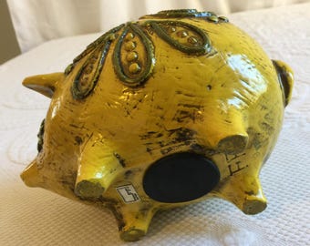 1960年代のヴィンテージ、黄色い豚の貯金箱。黄色い枠に渦巻く緑の模様
