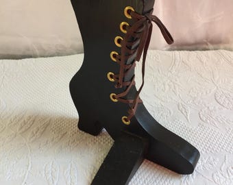 Tope de puerta con forma de bota victoriana. Madera pintada de negro con ojales y cordón marrón. Un detalle encantador para cualquier habitación.