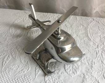 Vintage-Hubschrauber aus silbernem Aluminium mit drehbarem Hauptrotor. Steht zum Ausstellen auf seinen Kufen.