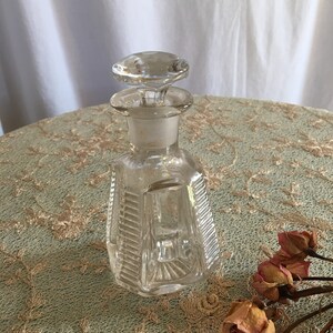 Vintage Clear Ridged Decorative Bottle With Etched Flower on Glass Stopper. Old and Unique Bottle. Sunburst Design on Bottom.