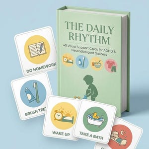 以下が含まれることがあります： 「The Daily Rhythm」というタイトルの本で、「ADHDと神経多様性の成功のための40枚のビジュアルサポートカード」という副題が付いています。「Do Homework」、「Brush Tee」、「Wake Up」、「Take a Bath」、「Go to Sleep」などのテキストが書かれたイラストカードがいくつか散らばっています。