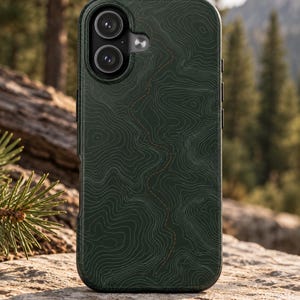 May include: A dark forest green smartphone case featuring a white topographic map line pattern across the back surface. The design includes a single vertical dashed orange line running through the center. The case has a raised camera cutout.