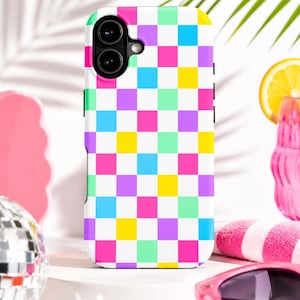 May include: A white phone case featuring a vibrant checkerboard design in pink, purple, yellow, blue, and green. The case has a dual-lens camera aperture and black side buttons. The case is on a white surface.