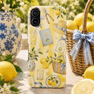 May include: A yellow and white striped phone case featuring a pattern of lemons, a straw hat, a blue and white pitcher, a wicker basket, a book titled The Lemon Grove Club, a glass of lemonade, and a candle with the text Citrus Blossom.