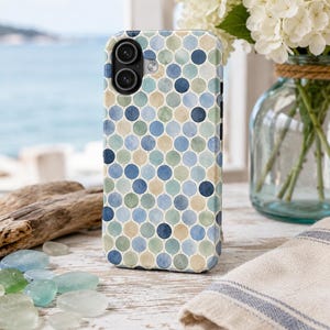 May include: A smartphone case featuring a repeating pattern of watercolour-style circles in shades of navy blue, light blue, sage green, and beige. The case has a cutout for a dual-lens camera system on the upper left side and a smooth, rounded edge design.