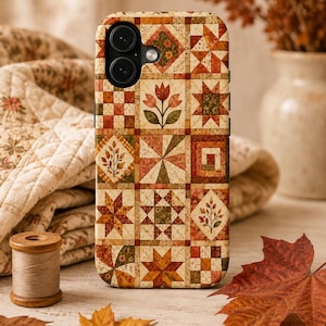 May include: A smartphone case featuring a grid-based patchwork quilt design in warm autumn colors. The pattern includes various geometric shapes, floral motifs, and star patterns in shades of orange, brown, cream, and green, with a dual camera cutout.