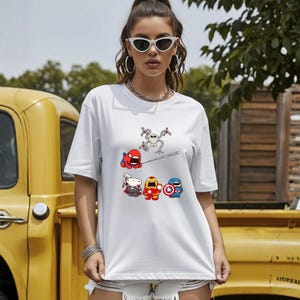 Może przedstawiać: Biały t-shirt z postaciami superbohater&oacute;w z kresk&oacute;wek. Grafika zawiera Spider-Mana, Thora, Iron Mana i Kapitana Amerykę. Koszulka jest w stylu casual z kr&oacute;tkim rękawem.