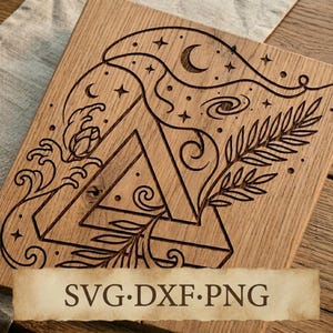 May include: A rectangular wooden board featuring a laser-engraved design of a Penrose triangle surrounded by celestial elements including a crescent moon, stars, a galaxy, a fern leaf, and wave patterns. The text SVG DXF PNG is visible below.