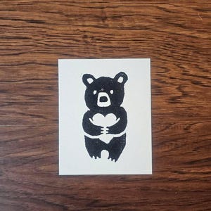 May include: A set of three ceramic mugs with a speckled, cream-colored glaze. Each mug features a different hand-painted floral design in shades of blue, green, and yellow. The mugs have a simple, rounded shape and a comfortable handle.