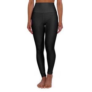 May include: Solid black high-waisted leggings featuring a smooth, form-fitting silhouette that extends to the ankles. The garment has a wide, supportive waistband and a clean, minimalist design with no visible patterns, textures, or additional hardware.