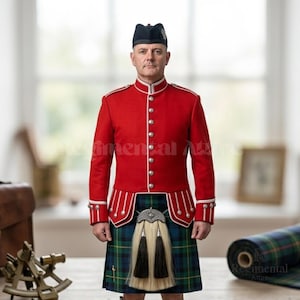 Pode incluir: Uma pessoa vestindo uma jaqueta vermelha com detalhes brancos e botões prateados, um chapéu preto e um kilt xadrez verde, azul e preto. A roupa inclui um sporran. Uniforme militar escocês tradicional.