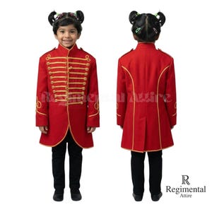 May include: A red military-style jacket with gold trim and buttons, paired with black pants. The jacket features a high collar and decorative gold accents. The outfit is designed for children and is suitable for costumes or special events.