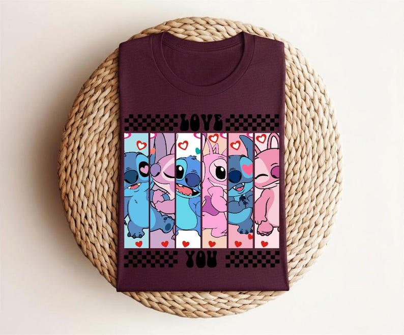 May include: Burgundy t-shirt featuring a colorful graphic of cartoon characters with the words "LOVE YOU" in a checkerboard design. The characters are in shades of blue and pink, with hearts.
