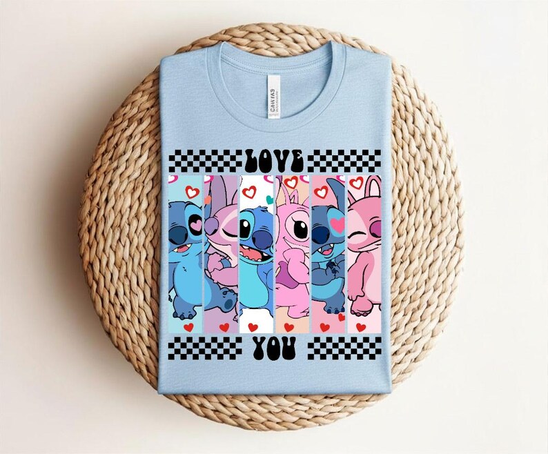 May include: Light blue t-shirt featuring a graphic of Stitch and Angel characters with the words "LOVE YOU". The design includes hearts and a checkered pattern, perfect for fans of the animated series.