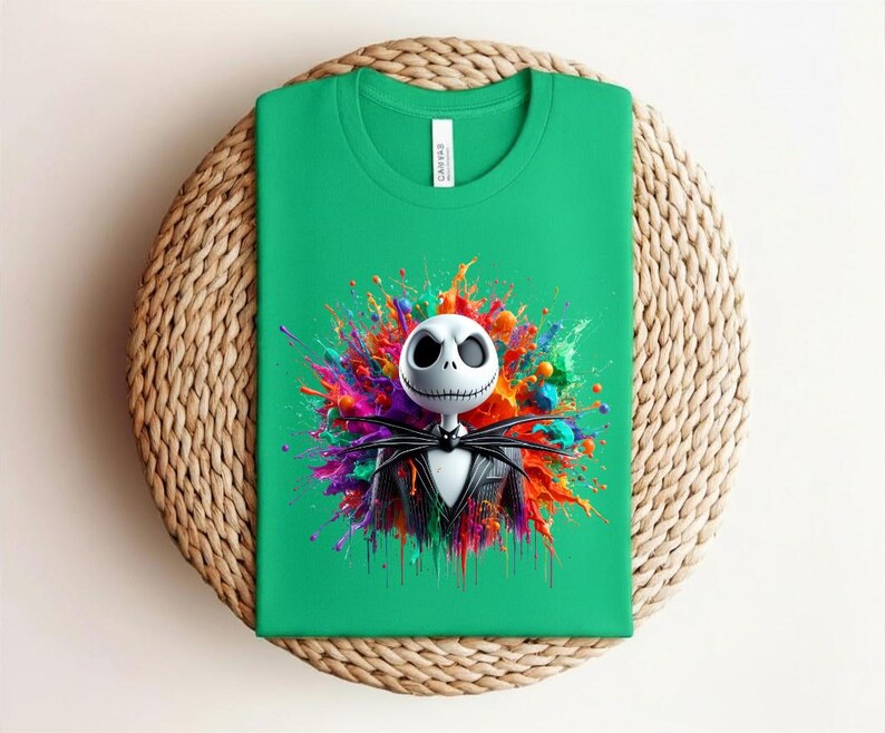 May include: A bright green t-shirt featuring a graphic of a white skull character with large black eyes and a stitched mouth, wearing a black pinstripe suit and bat bowtie, centered against a vibrant, multi-colored paint splatter background.