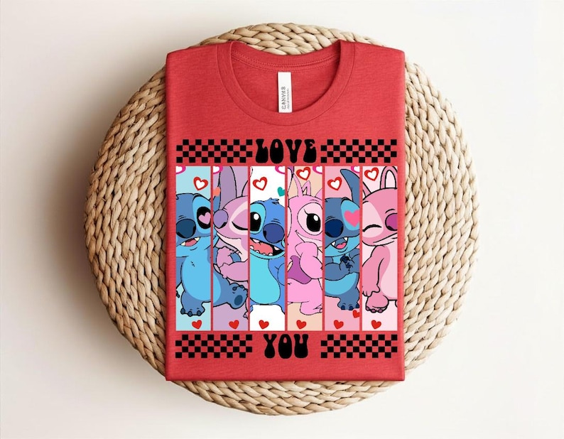 May include: Red t-shirt featuring a graphic of cartoon characters in shades of blue and pink, with the words "LOVE YOU" in black. The design includes hearts and a checkered pattern.