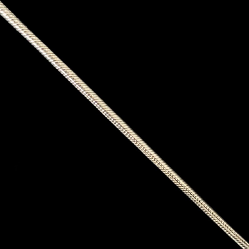 May include: A silver snake chain necklace.