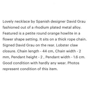 May include: A delicate necklace featuring a round orange howlite stone in a flower setting. The necklace is made of rhodium-plated metal and has a lobster claw closure. The chain is 44 cm long and 2 mm wide. The pendant is 2 cm high and 1.6 cm wide. The necklace is in good condition with minimal wear.