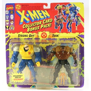 May include: X-Men Collector Card Bonus Pack featuring Strong Guy and Tusk action figures. The figures are in a sealed plastic package with a red, yellow, and purple background. The packaging includes the Marvel Comics and Toy Biz logos, and the text "Exclusively Sold at Walmart".