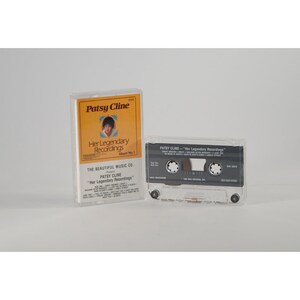 Op de afbeelding: Een cassettebandje met een gele en oranje hoes met een foto van Patsy Cline. De hoes heeft de tekst "Patsy Cline Her Legendary Recordings Album No. 1" en "The Beautiful Music Co. Presents Patsy Cline "Her Legendary Recordings".