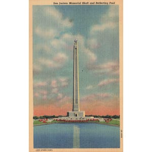 May include: Vintage postcard featuring the San Jacinto Memorial Shaft and Reflecting Pool. The tall monument is centered, reflecting in the pool below. The sky is a mix of blue and white clouds, with a hint of orange at the horizon.