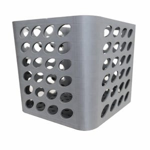 May include: A gray, cube-shaped storage basket with numerous evenly spaced circular holes. The basket has rounded corners and a textured surface, suitable for organizing items. The design is modern and minimalist.