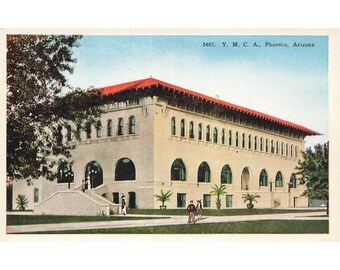 May include: A vintage postcard showing a large, beige building with a red tiled roof. The building has numerous windows and arched doorways. The postcard is titled "5407. Y. M. C. A. Phoenix, Arizona."