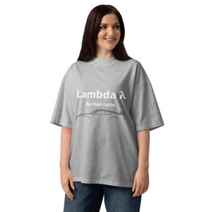 以下が含まれることがあります： 「Lambda Air-fuel ratio」の白文字がプリントされたライトグレーのTシャツ。その下に黒いスポーツカーのシルエット。ゆったりとしたフィット感のTシャツです。