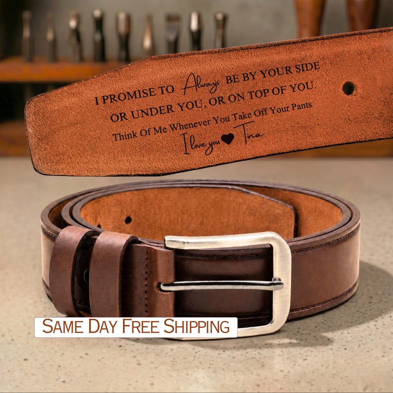 May include: A brown leather belt with a silver buckle. The belt has a message engraved on the inside that reads "I PROMISE TO Always BE BY YOUR SIDE OR UNDER YOU, OR ON TOP OF YOU. Think Of Me Whenever You Take Off Your Pants I love you Tina."