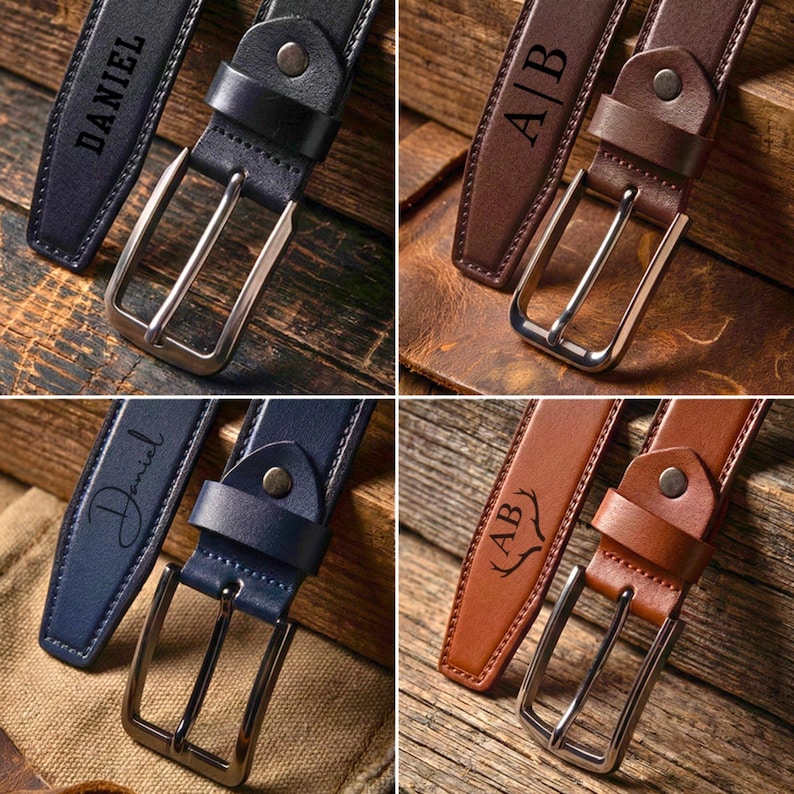 May include: Four leather belts in navy blue and brown, each with a silver buckle. Two belts are engraved with the name "Daniel", and the other two are engraved with initials "A|B". The belts are displayed on a wooden surface.