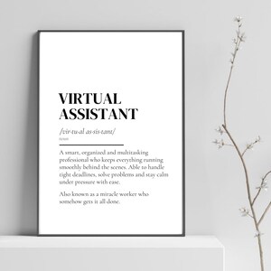 May include: A framed print featuring the text "VIRTUAL ASSISTANT" in a bold, black font. The definition of a virtual assistant is provided below, describing a professional who keeps everything running smoothly. The print is in a black frame.
