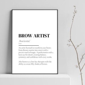 以下が含まれることがあります： 黒いフレームに入ったプリントで、太字の黒いフォントで「BROW ARTIST」という言葉が書かれています。眉アーティストの定義が下にあり、そのスキルについて説明しています。プリントは白い表面に表示されています。