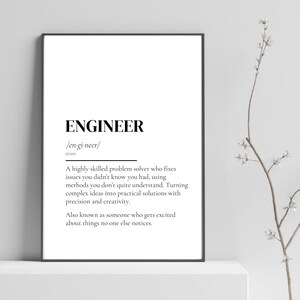 May include: A framed print featuring the definition of "ENGINEER" in black text on a white background. The definition describes an engineer as a skilled problem solver. The print is in a black frame.
