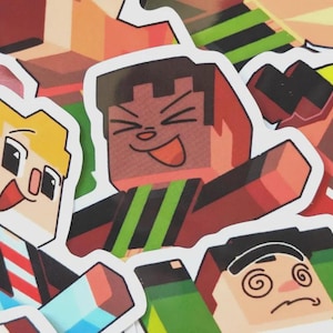May include: A collection of colorful cartoon character stickers. The stickers feature various blocky characters with expressive faces, including a character with a red face and green stripes. The stickers are on a white background.