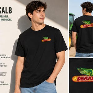 Peut inclure: Un t-shirt noir à manches courtes avec un petit logo sur la poitrine gauche et une version plus grande dans le dos. Le logo représente un épi de maïs jaune avec des ailes vertes et le texte rouge DEKALB. Le t-shirt est porté avec un jean bleu.