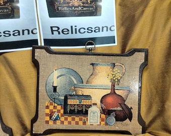 These pieces are a classic example of the Early American style that defined mid-century home decor. They feature beautiful kitchen still-lif