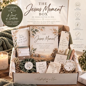 May include: A subscription box titled The Jesus Moment Box containing a devotional book, a bookmark with a tassel, gratitude scripture cards, a green scrunchie with a tag, a small pouch, three pens, a prayer card, and a circular sticker with floral art.