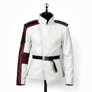 May include: White jacket with a high collar, black epaulettes, and a black belt with a silver buckle. The left sleeve is burgundy with black accents. The jacket is displayed on a black mannequin.