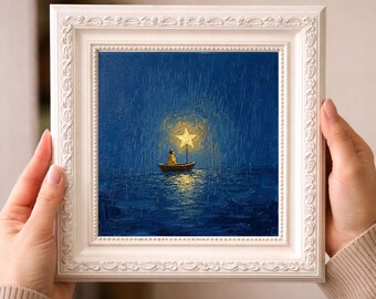 Puede incluir: Una pintura enmarcada representa a una persona en un pequeño bote bajo una estrella brillante. La obra de arte está ambientada sobre un fondo azul oscuro con lluvia. El marco blanco tiene un diseño decorativo y ornamentado. La pintura evoca una sensación de asombro y tranquilidad.