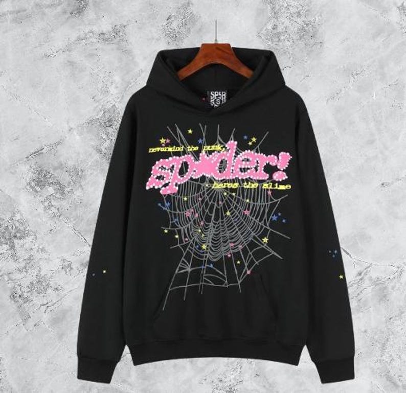 Puede incluir: Sudadera con capucha negra con un dise&ntilde;o gr&aacute;fico que presenta el texto rosa "spider!" y una telara&ntilde;a. El dise&ntilde;o incluye estrellas y el texto "nevermind the punk, here's the slime". La sudadera tiene un bolsillo delantero y una capucha con cord&oacute;n.