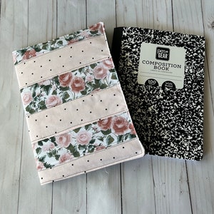 May include: A floral notebook cover with a pink background and black polka dots, paired with a black and white composition book. The cover features rose patterns and the text "Pen+Gear Composition Book".