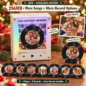 Op de afbeelding: Een witte vierkante muziekspeler met een centrale vinylplaat-afbeelding met een foto van een gezin en een hond. De tekst luidt "OUR CHRISTMAS MEMORIES" en "NEW UPGRADED EDITION 256MB More Songs More Record Options". Inclusief negen ronde fotoplaten.