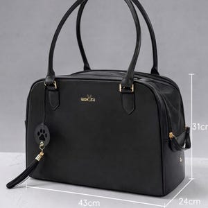 May include: Black pet carrier bag with dual handles, measuring 43cm long, 24cm wide, and 31cm high. Features a gold zipper, gold hardware, and a paw print charm. The brand name "wakucu" is displayed in gold lettering.