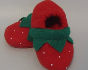 May include: Red felt slipper shaped like a strawberry with green felt leaves and white felt seeds.