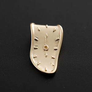 Puede incluir: Una taza de cerámica blanca con asa negra y el texto "But First, Coffee" en negrita negra. La taza se encuentra sobre un fondo borroso, sugiriendo un ambiente acogedor.