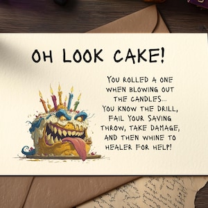 May include: A humorous birthday card with the text "OH LOOK CAKE!". The card features a cartoon illustration of a monster cake with candles and the text: "You rolled a one when blowing out the candles..."