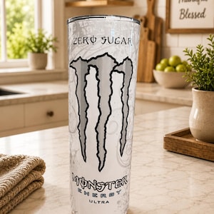 K&ouml;nnte beinhalten: Ein hoher, zylindrischer wei&szlig;er Becher mit dem schwarzen Monster Energy Krallen-Logo, dem Schriftzug "ZERO SUGAR" oben und dem "MONSTER ENERGY ULTRA" Logo unten. Die Oberfl&auml;che ist mit einem dezenten, hellgrauen Wirbelmuster versehen.