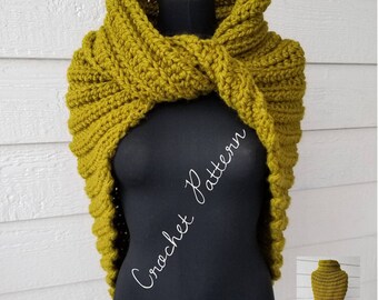May include: A chunky olive green crochet wrap with a ribbed texture and a twisted front design. The garment is displayed on a black mannequin and features the white text Crochet Pattern overlaid across the center of the piece.