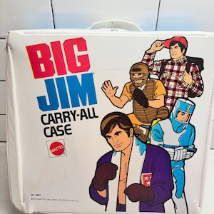 May include: A white Big Jim Carry-All Case by Mattel with a handle. The front features colorful illustrations of Big Jim in various outfits including a boxer, a baseball catcher, and a hiker. The text reads Big Jim Carry-All Case.