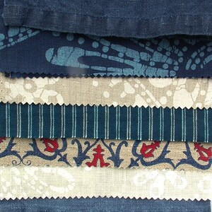 Pode incluir: Uma pilha de amostras de tecido em vários padrões e cores. A amostra superior é azul marinho liso, seguida por uma amostra azul marinho com um padrão azul claro. Outras amostras incluem listras, desenhos florais e cores sólidas.